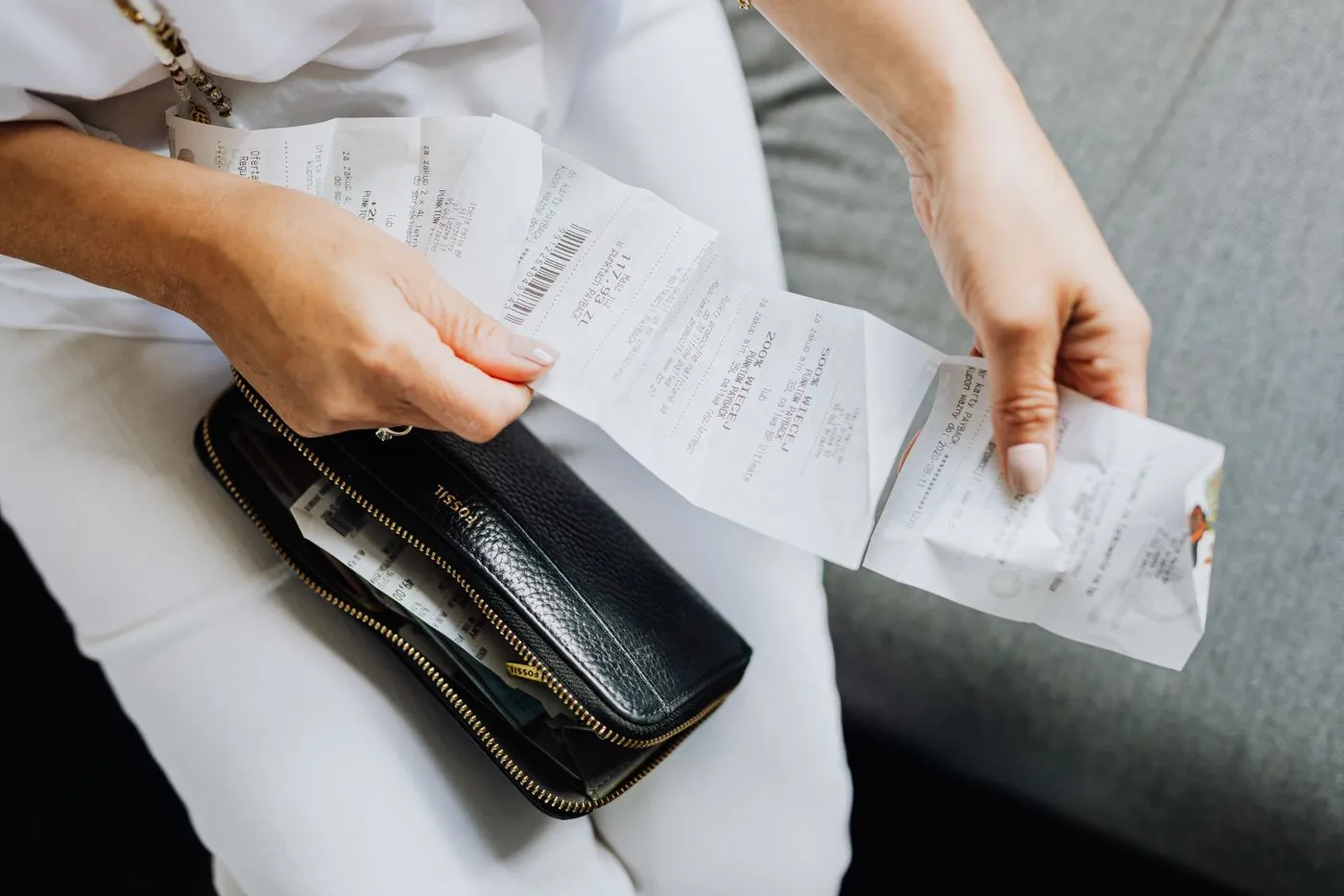 Tri de tickets de caisse et de justificatifs au-dessus d’un portefeuille